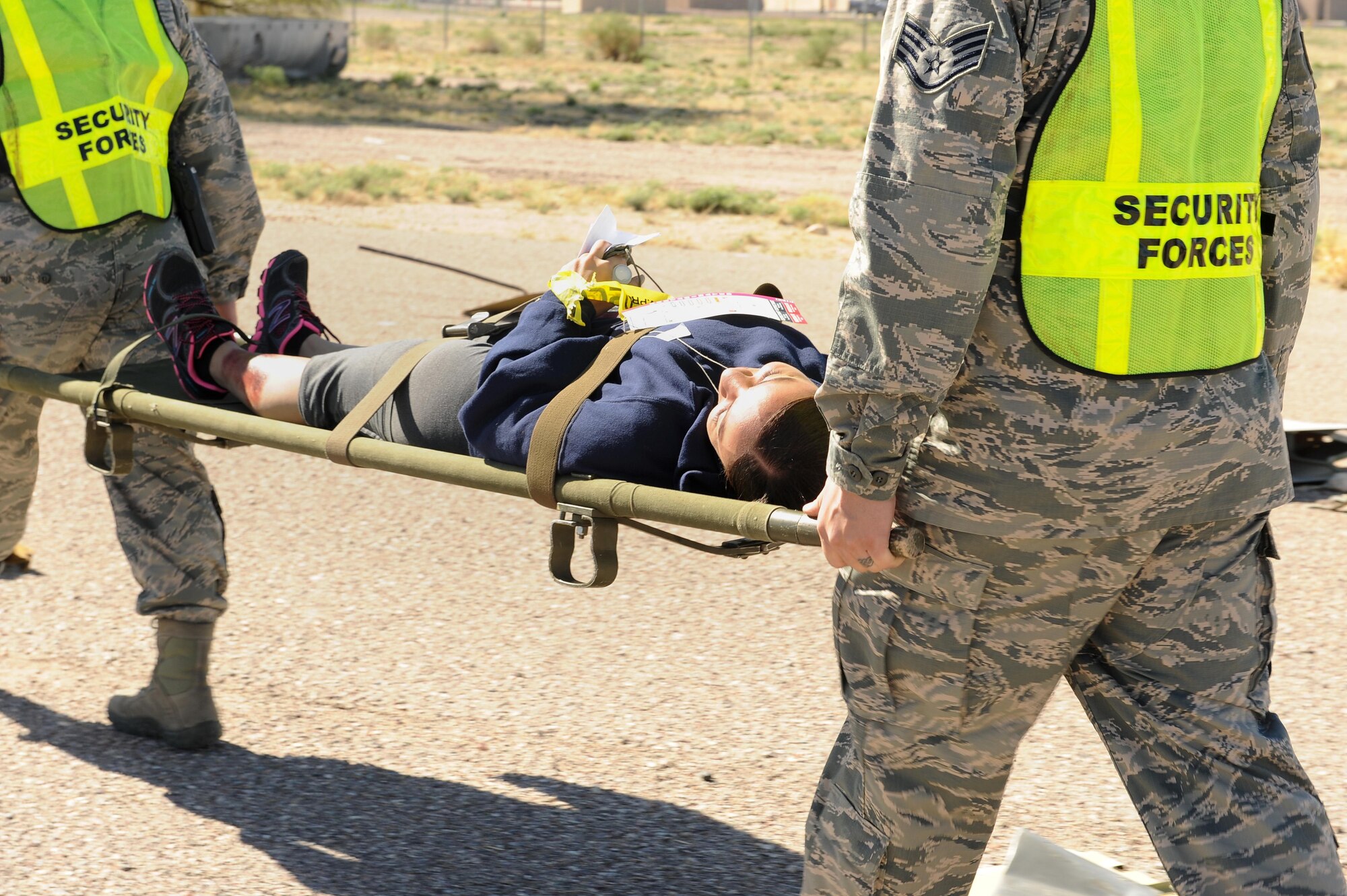 U.S. Air Force Staff Sgt. Melissa Nater, 355th Force Support Squadron moral, welfare and recreation assistant NCO in charge, is carried out of a simulated aircraft crash scene during the BUSHWHACKER 16-02 Aircraft Crash emergency management exercise at Davis-Monthan Air Force Base, Ariz., Feb. 24, 2016. Units from around base participated in the aircraft crash exercise to have their processes and procedures evaluated in order to identify strengths and weaknesses and allow them to be better prepared for future real-world incident response.(U.S. Air Force photo by Senior Airman Cheyenne A. Powers/ Released) 