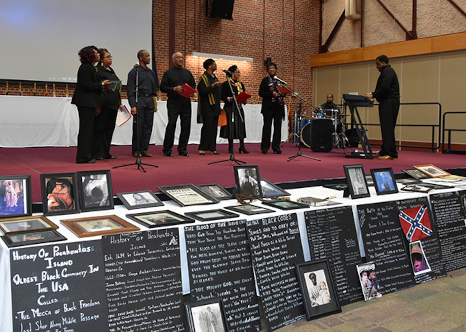 The Bellwood Choir, comprised Defense Logistics Agency employees on Defense Supply Center Richmond, Virginia, perform hymns during a Black History Month Observance Feb. 25, 2016 held on the center.  In front of the stage are historical displays depicting the history of the tragedies and triumphs of African-Americans pre-and-post Civil War era, along with historical information on Pocahontas Island, one of the first black communities in the United States, located on the Appomattox River in Petersburg, Virginia.  