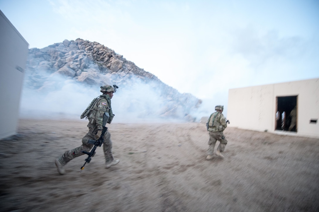 Soldiers maneuver between buildings during a clearance operation exercise in a mock town at the National Training Center, Fort Irwin, Calif., Feb. 18, 2016. U.S. Army photo by Staff Sgt. Alex Manne