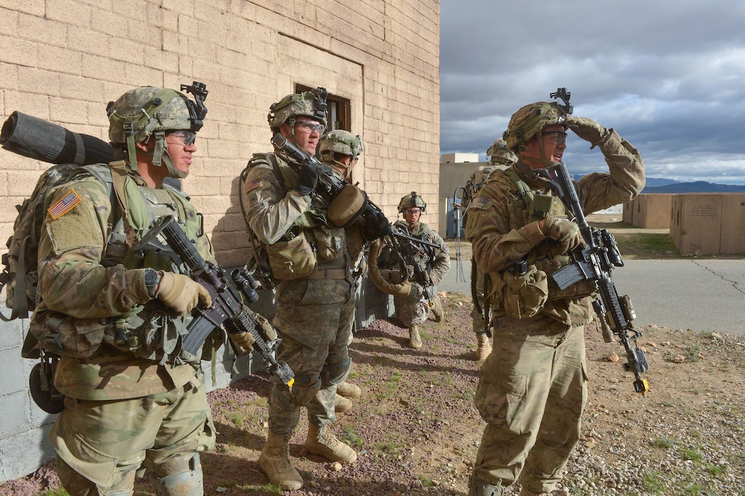 Soldiers provide security and scan for simulated enemy fighters during a clearance operation exercise in a mock town at the National Training Center, Fort Irwin, Calif., Feb. 18, 2016. U.S. Army photo by Staff Sgt. Alex Manne
