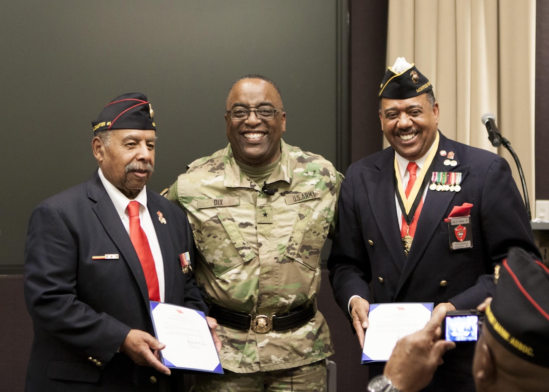 DLA Distribution commander, Army Brig. Gen. Richard B. Dix, center, presents star notes to Retired Marine Sgt. Henry N. Wilcots, left, and Retired Marine Master Gunnery Sgt. Joseph H. Geeter, III, right, during the Black History Month presentation in New Cumberland, Pa., on Feb. 24.