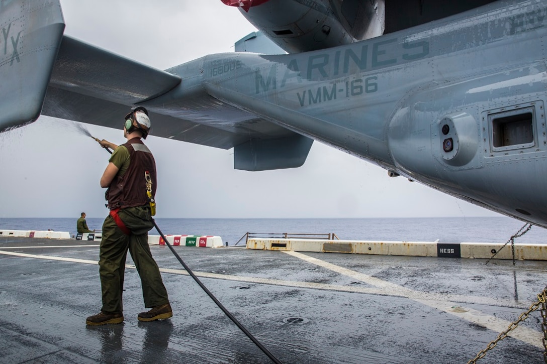 U.S. Marine Lance Cpl. James D. Galichia, a flight line mechanic with the 13th Marine Expeditionary Unit, rinses off the special solvent used to slow the corrosion process on aircraft aboard the USS New Orleans, at sea, Feb. 24, 2016. The solvent helps wash off the sea water that batters the aircraft during transit. More than 4,500 Sailors and Marines from the Boxer Amphibious Ready Group, 13th Marine Expeditionary Unit team are currently transiting the Pacific Ocean toward the U.S. 7th Fleet area of operations during a scheduled deployment. (U.S. Marine Corps photo by Lance Cpl. Alvin Pujols/RELEASED)