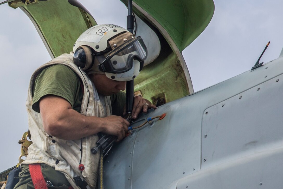 U.S. Marine Lance Cpl. Bryan J. VillaSeñor, an airframe mechanic with the 13th Marine Expeditionary Unit, installs a strut during an inspection of a U.S. Marine MV-22 Osprey aboard the USS New Orleans, at sea, Feb. 24, 2016. All the components of the ship are inspected and kept up to date with a wide variety of inspections and tests. More than 4,500 Sailors and Marines from the Boxer Amphibious Ready Group, 13th Marine Expeditionary Unit team are currently transiting the Pacific Ocean toward the U.S. 7th Fleet area of operations during a scheduled deployment. (U.S. Marine Corps photo by Lance Cpl. Alvin Pujols/RELEASED)