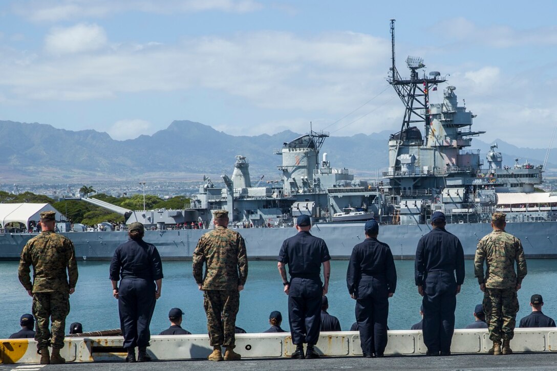 U.S. Marines and Sailors with the 13th Marine Expeditionary Unit and Boxer Amphibious Ready Group aboard the USS New Orleans stand at attention in preparation to render honors to the Pearl Harbor memorial, Feb. 23, 2016. More than 4,500 Sailors and Marines from the Boxer Amphibious Ready Group, 13th Marine Expeditionary Unit team are currently transiting the Pacific Ocean toward the U.S. 7th Fleet area of operations during a scheduled deployment. (U.S. Marine Corps photo by Lance Cpl. Alvin Pujols/RELEASED)