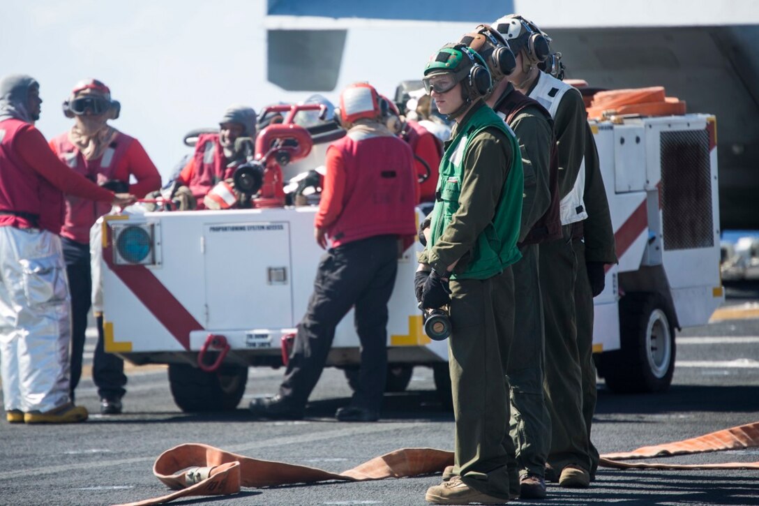 U.S. Marines and Sailors with the Boxer Amphibious Ready Group and 13th Marine Expeditionary Unit, conduct aircraft fire hazard drills aboard the USS Boxer, Feb. 24, 2016. More than 4,500 Sailors and Marines from the Boxer ARG, 13th MEU team are currently transiting the Pacific Ocean toward the U.S. 7th Fleet area of operations during a scheduled deployment. (U.S. Marine Corps photo by Sgt. Briauna Birl/RELEASED)