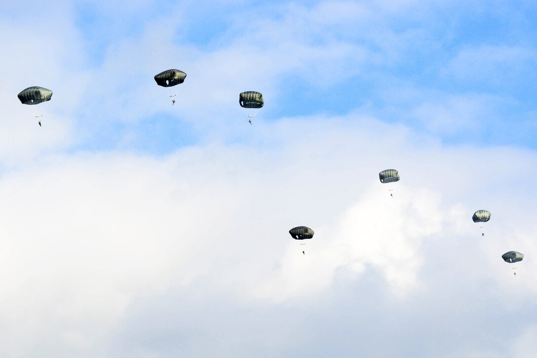 Paratroopers descend to the drop zone after jumping from a UH-60 Black Hawk helicopter over Grafenwoehr Training Area, Germany, Feb. 18, 2016. U.S. Army photo by Pfc. Emily Houdershieldt