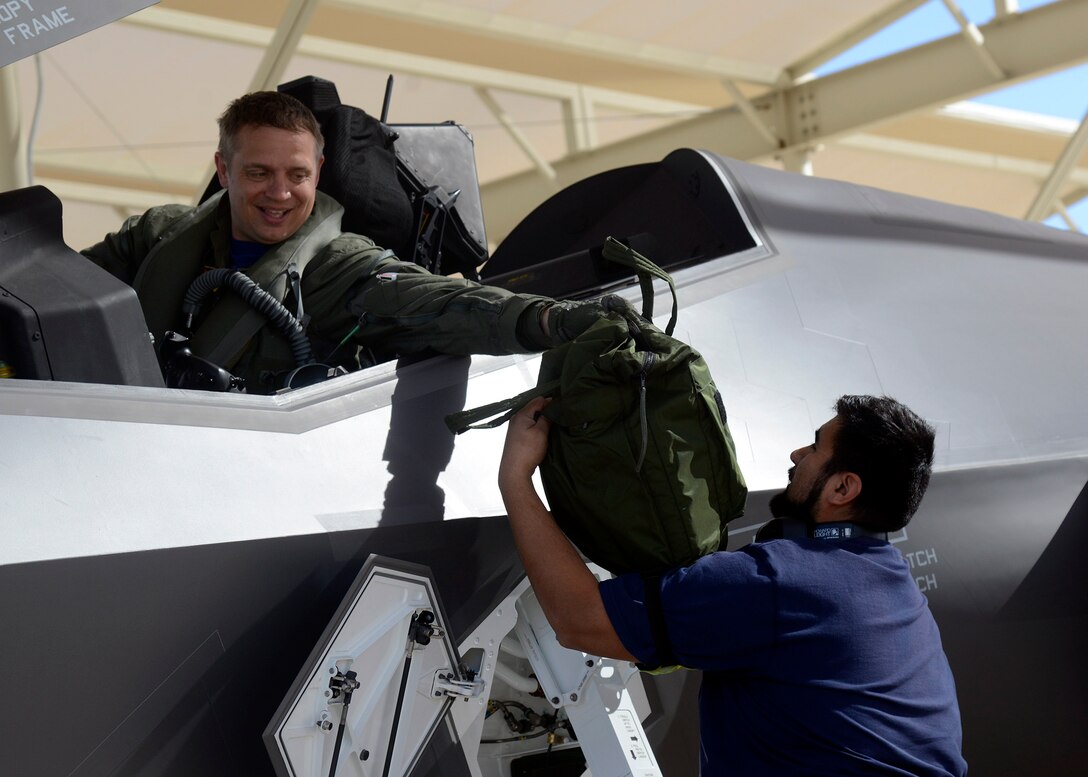 Lt. Col. Martin Tesli, 62nd Fighter Squadron Norwegian instructor pilot, passes his gear to Ello Puga-Orozco, 62nd Aircraft Maintenance Unit crew chief, after completing the 100th flying hour milestone at Luke Air Force Base Feb. 26. By 2024, Luke is scheduled to have six fighter squadrons and 144 F-35s. Norway will have seven F-35s stationed at Luke.