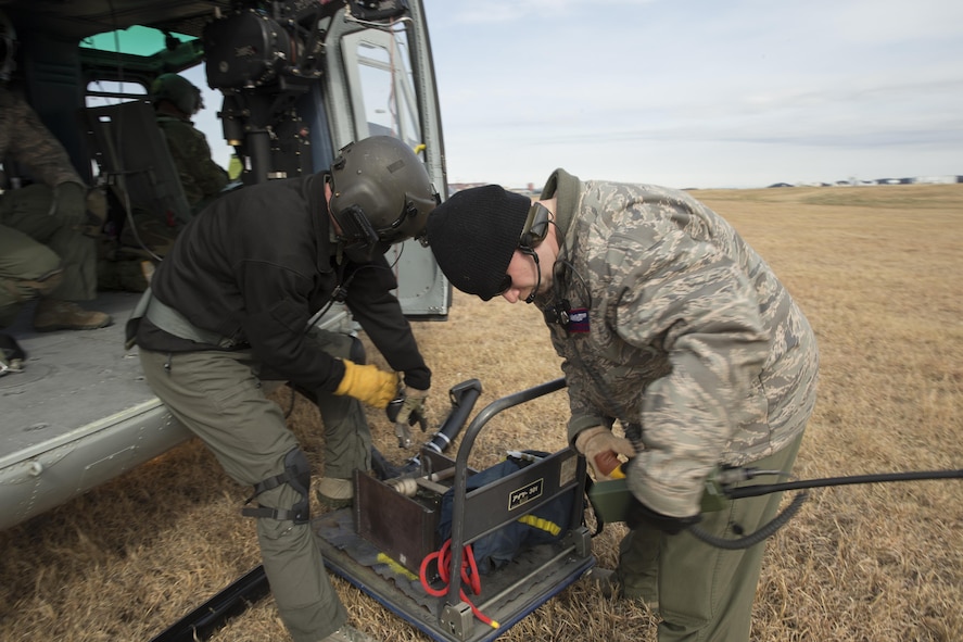 (Left to right) Tech. Sgt. Christopher Pound, 36th Rescue Squadron special missions aviator evaluator, and Tech. Sgt. Christopher Rector, 459th Airlift Squadron flight engineer, hoisted 350 lbs. during a hoist training exercise at Yokota Air Base, Japan, Feb. 22, 2016. The 459th AS recently improved their search and rescue capabilities by outfitting two Hueys with new rescue hoists. Previously, without the hoist, conducting rescues in small, tight areas wasn’t feasible. Now, 459th AS aircrew can conduct any type of search and rescue scenario throughout the Kanto Plains. (U.S. Air Force photo by Osakabe Yasuo/Released) 