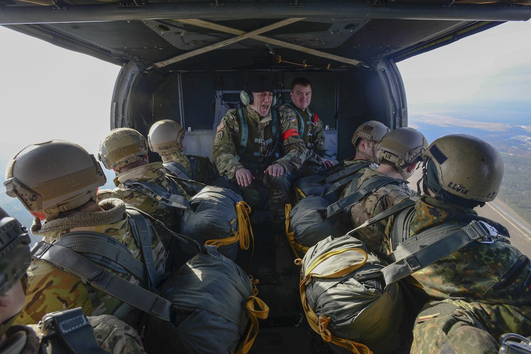 A U.S. Army jumpmaster, center, gives commands to U.S. troops and German soldiers inside a UH-60 Black Hawk helicopter as part of an airborne exercise over Grafenwoehr Training Area, Germany, Feb. 18, 2016. Army photo by Pfc. Emily Houdershieldt
