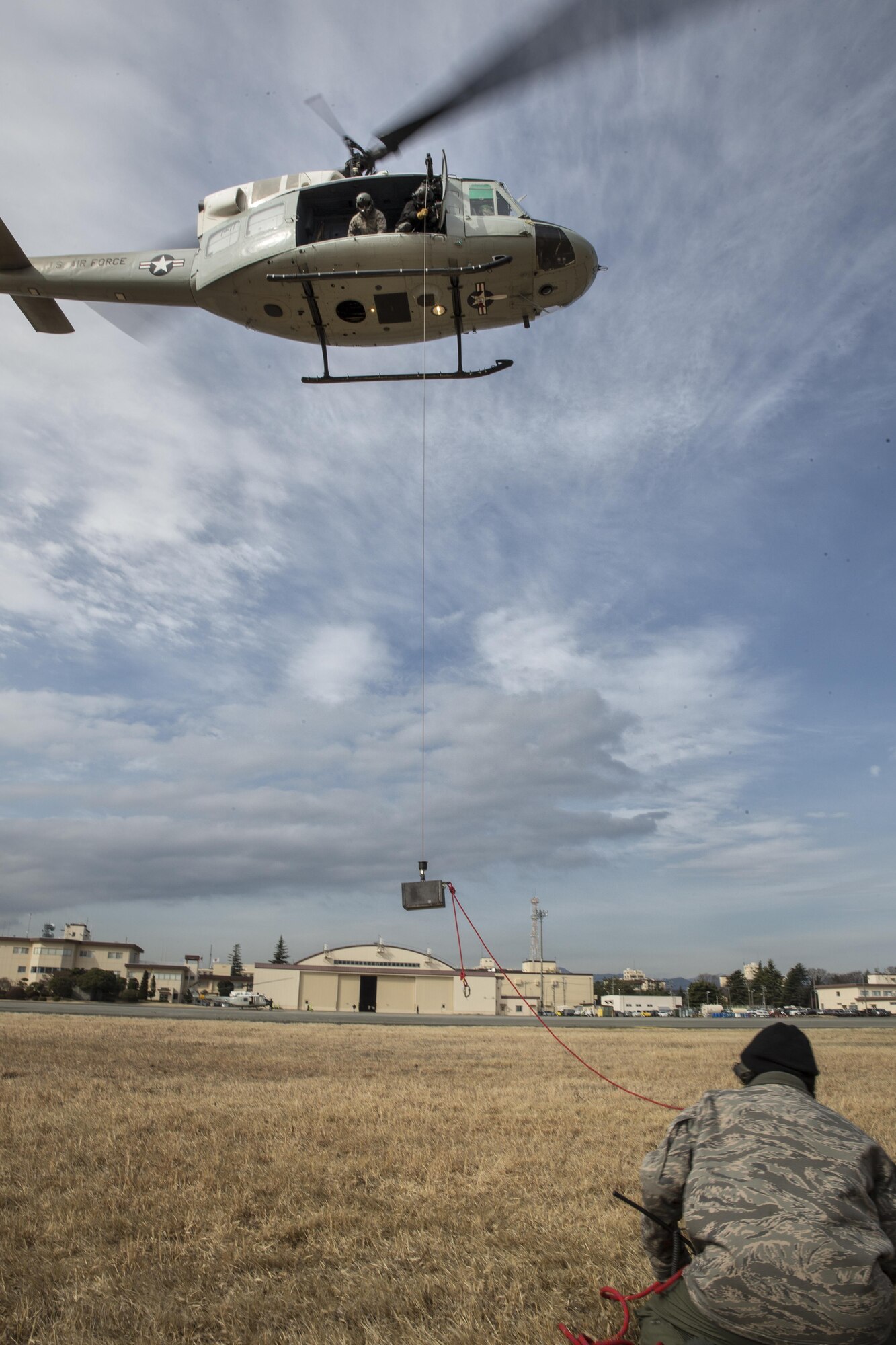 Members of the 459th Airlift Squadron perform hoist weight test at Yokota Air Base, Japan, Feb. 22, 2016. The 459th AS recently improved their search and rescue capabilities by outfitting two UH-1N Hueys with new rescue hoists. Previously, without the hoist, conducting rescues in small, tight areas wasn’t feasible. Now, 459th AS aircrew can conduct any type of search and rescue scenario throughout the Kanto Plains. (U.S. Air Force photo by Osakabe Yasuo/Released) 