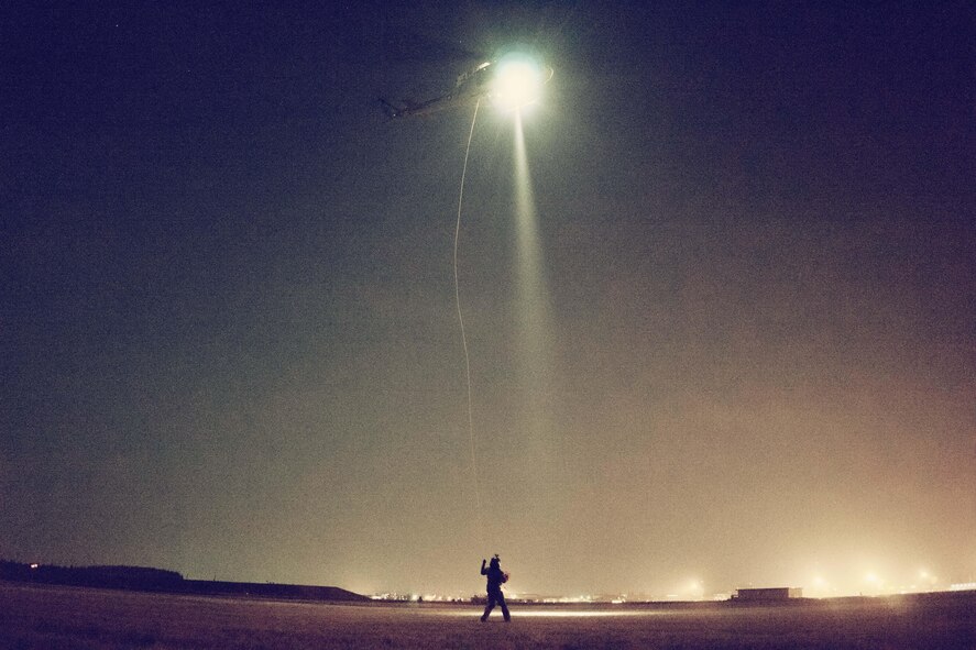 Tech. Sgt. Michael Wright, 459th Airlift Squadron UH-1N Huey flight engineer, handles a UH-1N hoist cable at Yokota Air Base, Japan, Feb. 23, 2016. For 459th AS special missions aviators to become certified to operate the hoist, SMA instructors with the 512th Rescue Squadron, Kirtland AFB, New Mexico, and the 36th RQS, Fairchild AFB, Washington, arrived at Yokota to train alongside flight engineers. The requalification process included day and night hoist operations with the supervision of instructors. (U.S. Air Force photo by Airman 1st Class Delano Scott/Released)