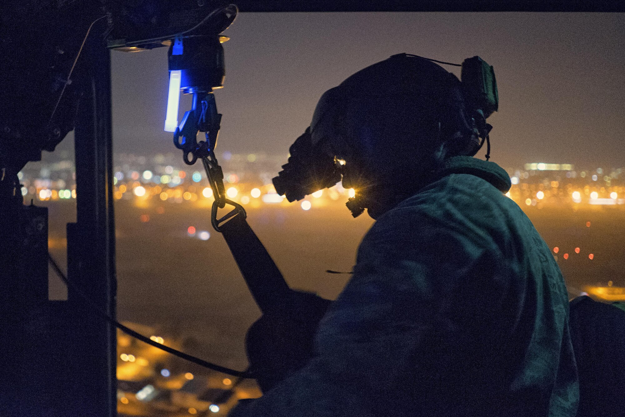 Tech. Sgt. Michael Wright, 459th Airlift Squadron UH-1N Huey flight engineer, reels in a UH-1N hoist cable at Yokota Air Base, Japan, Feb. 23, 2016. For 459th AS special missions aviators to become certified to operate the hoist, SMA instructors with the 512th Rescue Squadron, Kirtland AFB, New Mexico, and the 36th RQS, Fairchild AFB, Washington, arrived at Yokota to train alongside flight engineers. The requalification process included day and night hoist operations with instructor supervision. (U.S. Air Force photo by Airman 1st Class Delano Scott/Released)