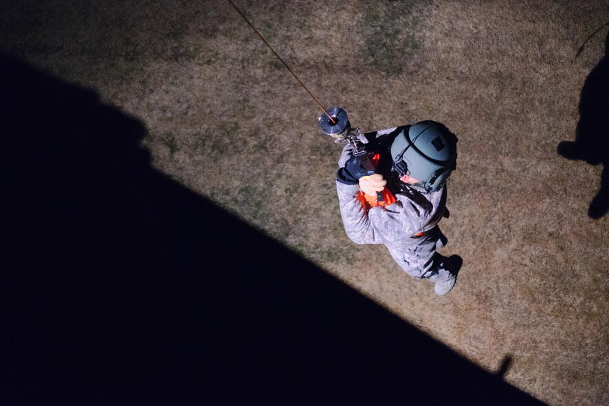 Staff Sgt. Nicholas Poe, 459th Airlift Squadron special missions aviator instructor and UH-1N flight engineer, uses a hoist to raise into the aircraft at Yokota Air Base, Japan, Feb. 23, 2016. For 459 AS’ special missions aviators to become certified to operate the hoist, SMA instructors with the 512th Rescue Squadron, Kirtland AFB, New Mexico, and the 36th RQS, Fairchild AFB, Washington, arrived at Yokota to train alongside flight engineers. (U.S. Air Force photo by Airman 1st Class Delano Scott/Released)