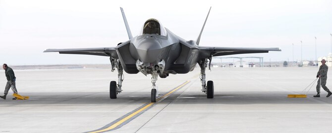 Two airmen remove the chalks from an F-35A preparing for departure from Mountain Home Air Force Base, Idaho, Feb. 12, 2016. The F-35 is a 5th generation multi-role fighter with stealth, electronic warfare and multi-spectral fused sensor capabilities needed to achieve unmatched levels of survivability and lethality in a contested environment. (U.S. Air Force photo by Airman 1st Class Jessica H. Evans/RELEASED)