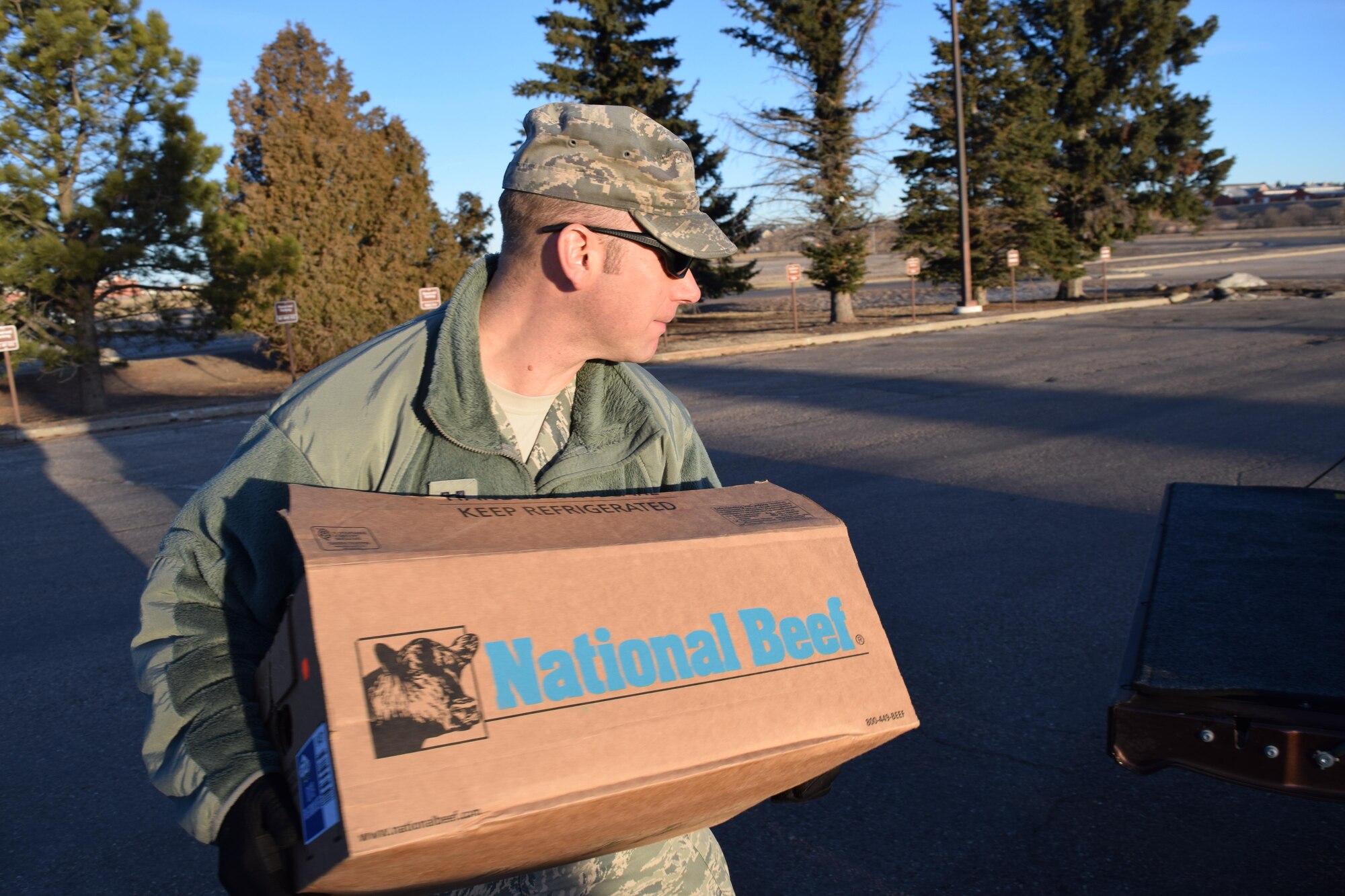 Chaplain (Capt.) Samuel McClellan, 90th Missile Wing Chaplain, carries a box of steaks to a truck Feb. 26, 2016. (Courtesy photo)