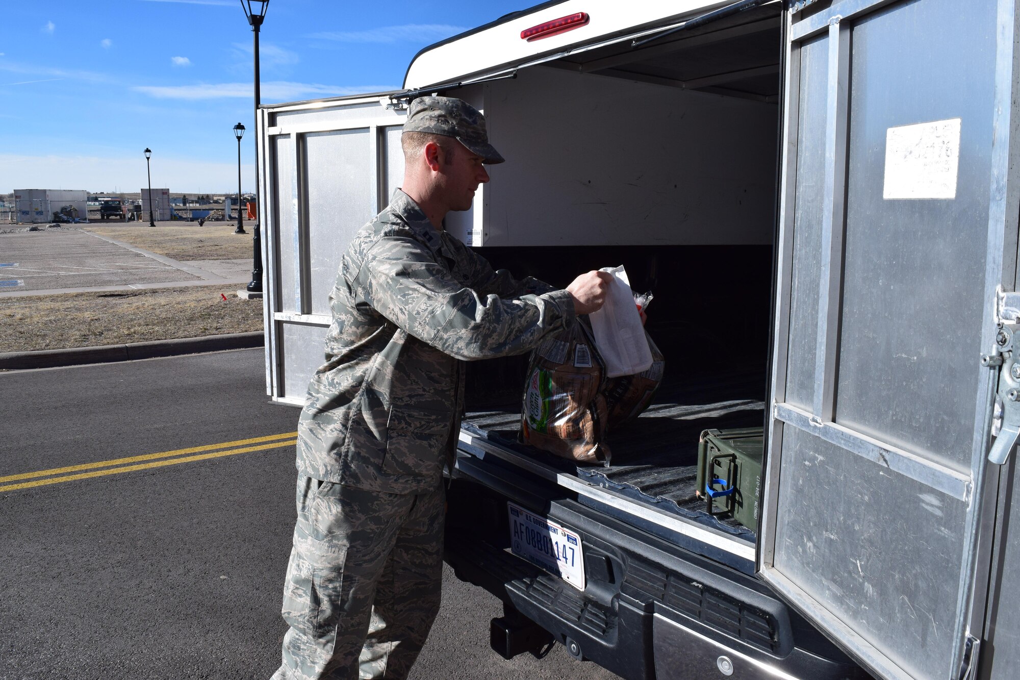 Chaplain (Capt.) Samuel McClellan, 90th Missile Wing Chaplain, carries a box of steaks to a truck Feb. 26, 2016. (Courtesy photo)
