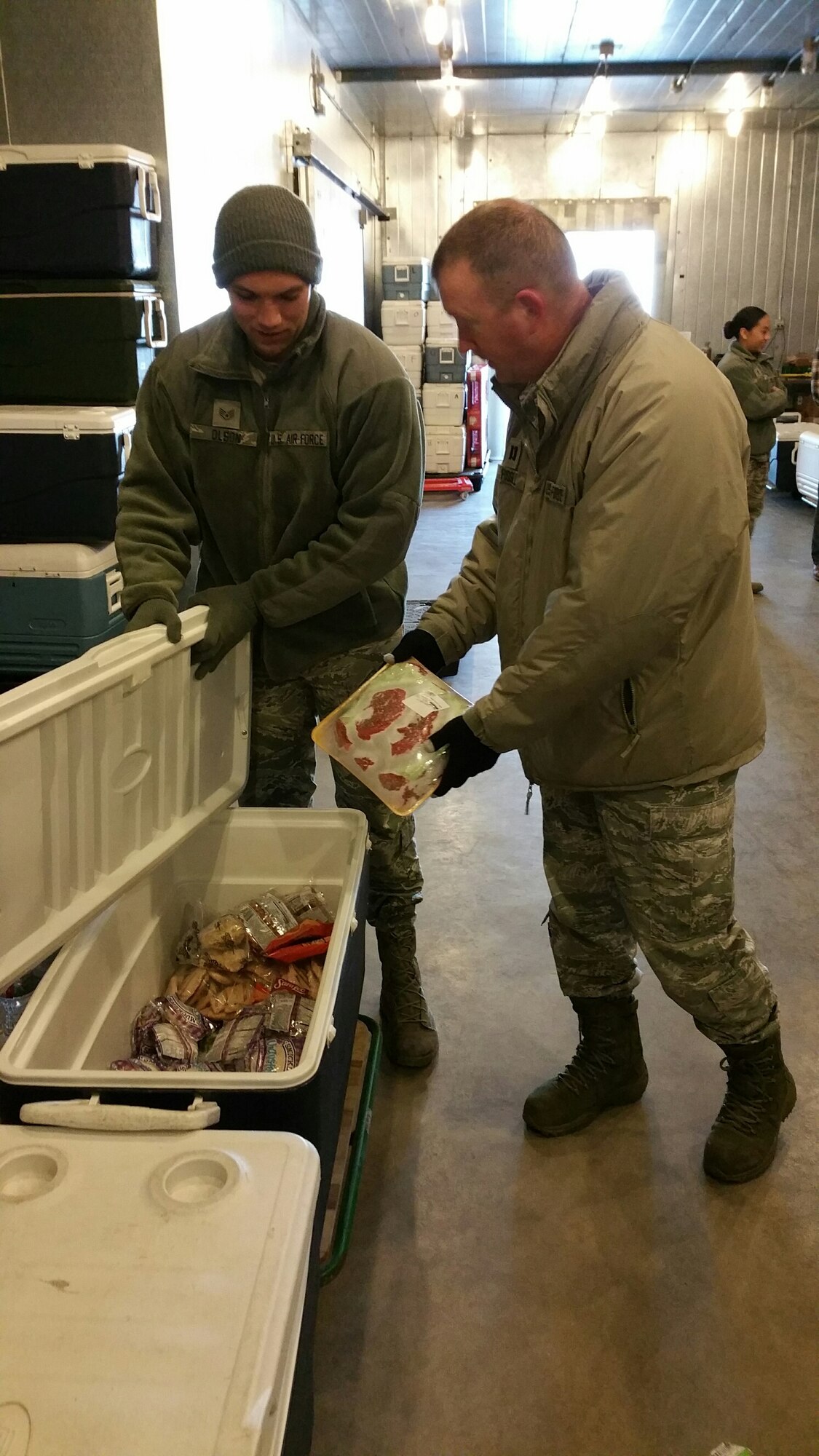 Chaplain (Capt.) Thomas Fussell, 90th Missile Wing Chaplain, and Staff Sgt. Jordan Olson, 90th Force Support Squadron missile feeding specialist, pack steaks into a cooler before transporting them out to the field Feb. 26, 2016. (Courtesy photo)