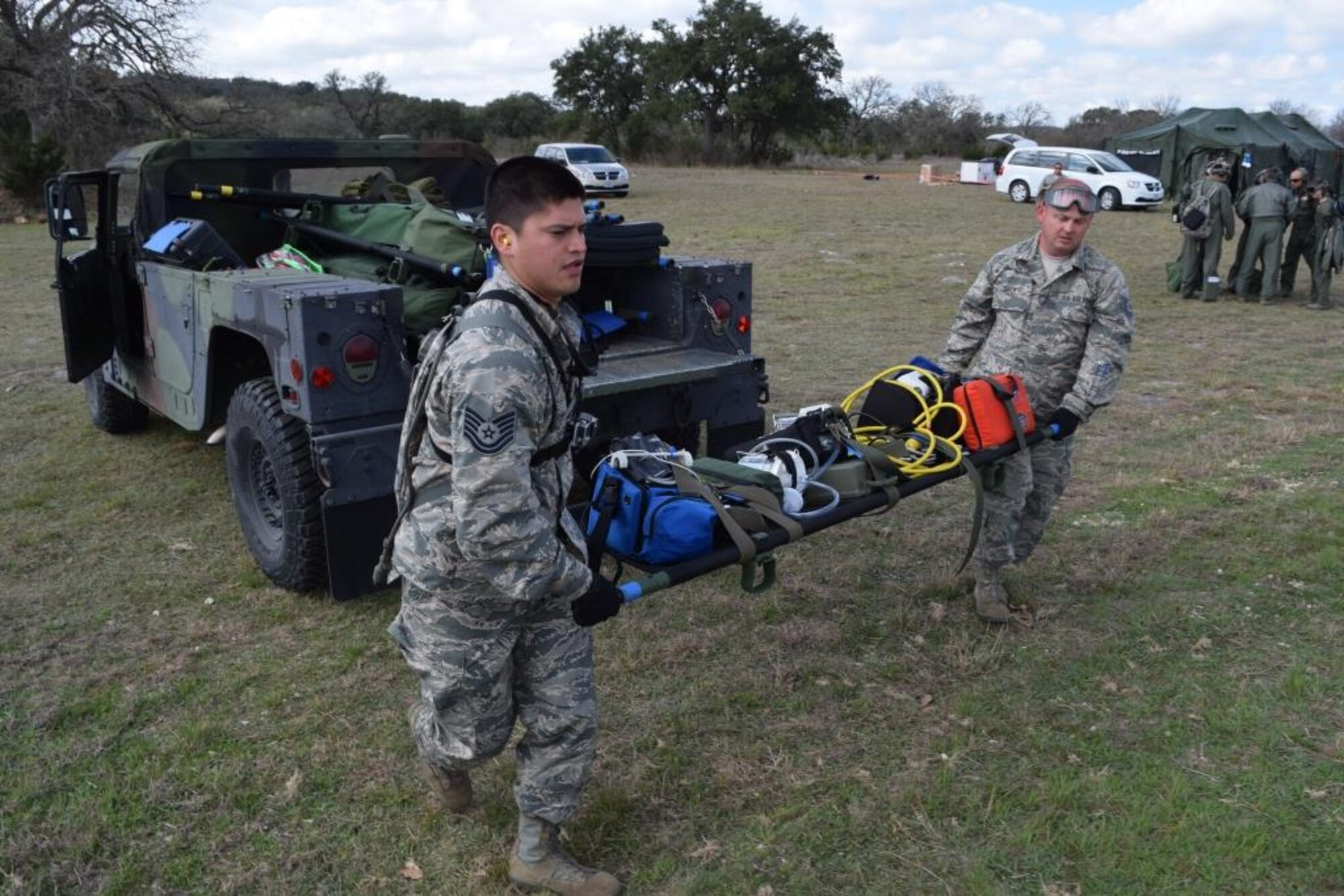 Tech. Sgts. Kristopher Orna (left)  and Joshua Smith, both assigned to the 433rd Aeromedical Evacuation Squadron, unload AE equipment and prepare it for loading on the out-bound flight during the Alamo Shield exercise at Camp Bullis Training Annex Feb. 27, 2016. Orna and Smith are working as a part of one of the two Aeromedical Evacuation Operations Teams who coordinate the air crews and provide operational and mission management support by coordinating the proper equipment necessary for the mission, directs AE ground support activities like mission launch and recovery, aircraft set up and configuration, and manages medical equipment and supplies. (U.S. Air Force photo/Senior Airman Bryan Swink)
