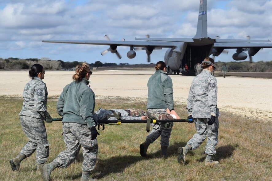 En-route Patient Staging System team members, from the 433rd Aeromedical Staging Squadron, transport a patient toward a C-130 Hercules during the Alamo Shield exercise held at Joint Base San Antonio-Lackland and Camp Bullis Training Annex, Texas Feb. 27, 2016. Alamo Shield is a comprehensive training exercise designed to deploy and exercise an aeromedical evacuation system in an initial urgent response scenario. (U.S. Air Force photo/Senior Airman Bryan Swink)