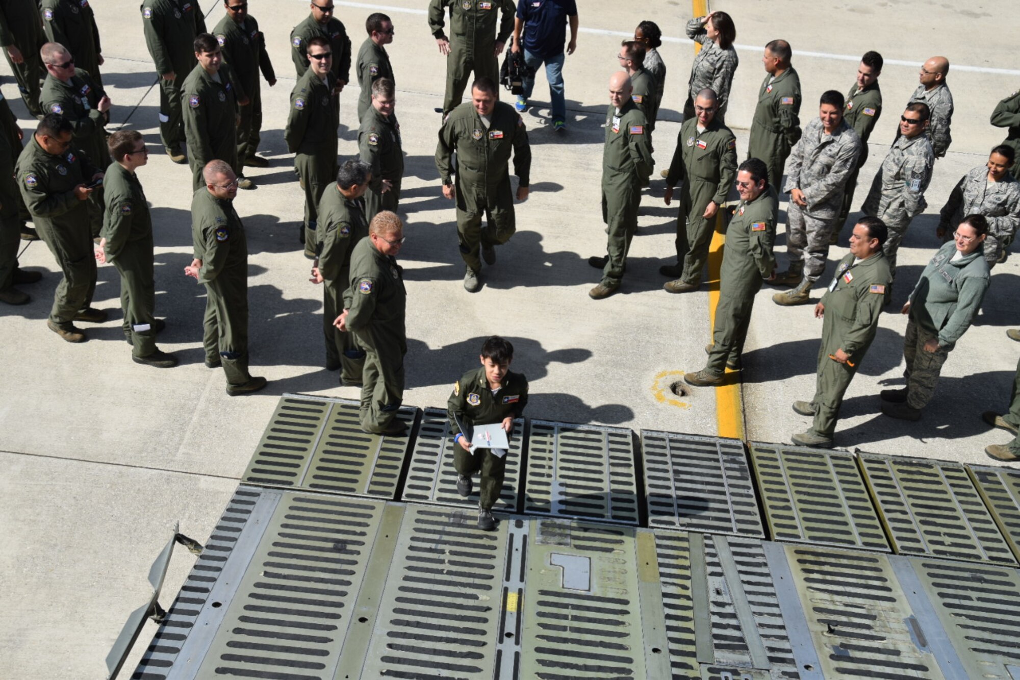 Honorary pilot, 2nd Lt. Zach Gutierrez, enters a C-5A Galaxy aircraft through its open visor, as members of the 433rd Airlift Wing on Joint Base San Antonio, Texas looks on.  Zach is the first Pilot of the Day under Wing’s new adopted program.  (U.S. Air Force photo by Tech. Sgt. Carlos J. Trevino) 