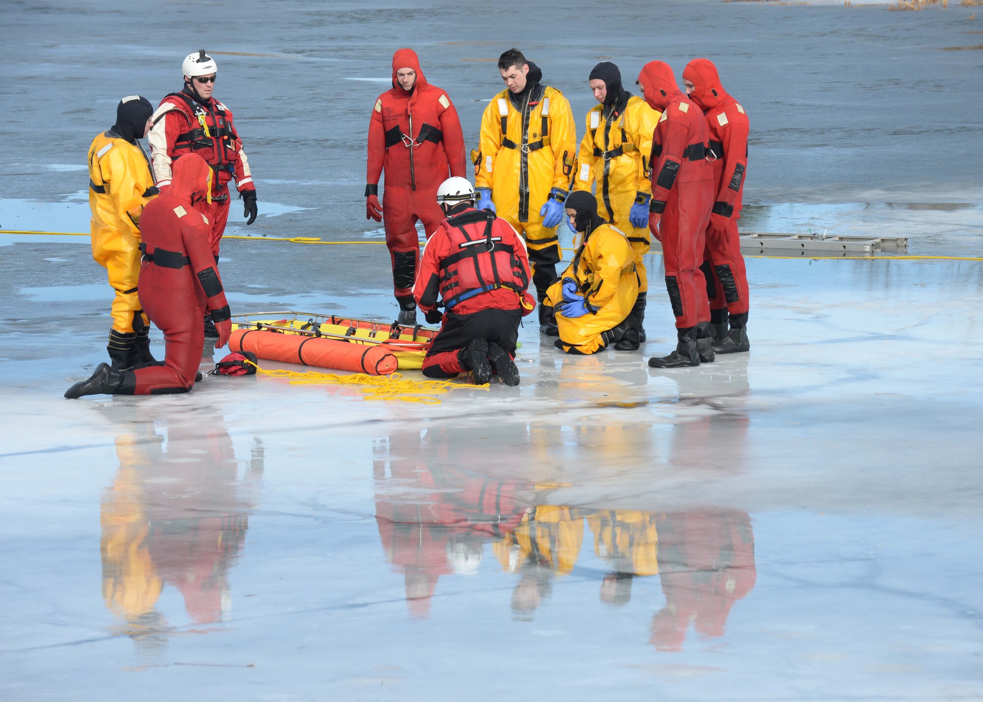 Airmen from the 28th Civil Engineer Squadron Fire Department learn about a stokes basket during ice rescue training at Ellsworth Air Force Base, S.D., Feb. 17, 2016. Throughout the training, Airmen practiced a wide range of rescue techniques, alternating between the roles of the rescuer and the victim. (U.S. Air Force photo by Senior Airman Rebecca Imwalle/Released)