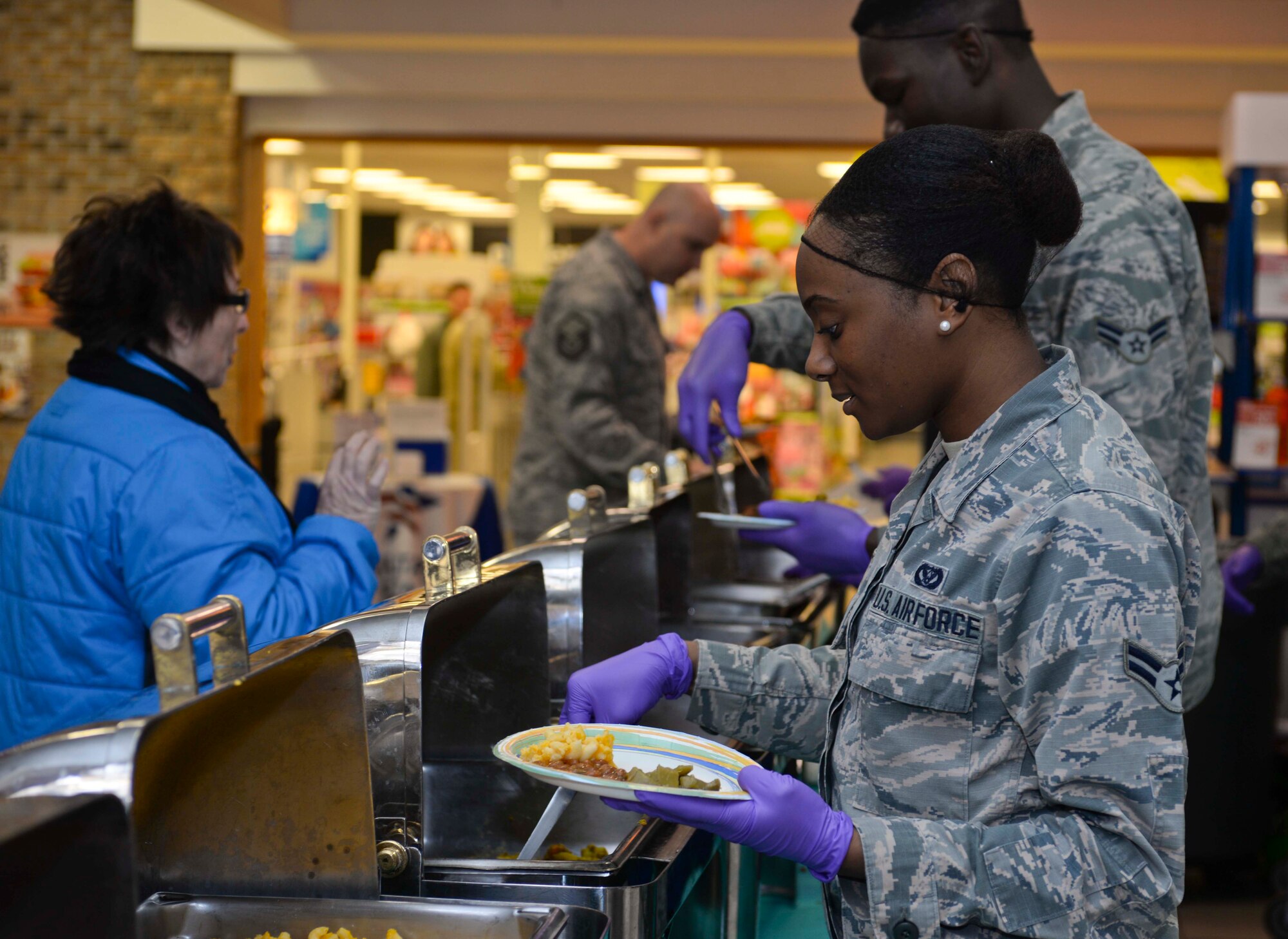 Airman 1st Class Janay Jones, 28th Civil Engineer Squadron engineer technician, serves food to the base community during the Black History Month luncheon at Ellsworth Air Force Base, S.D., Feb. 24, 2016. The luncheon had more than 10 dishes of African American cuisine with more than 80 people in attendance. (U.S. Air Force photo by Airman Sadie Colbert/Released)