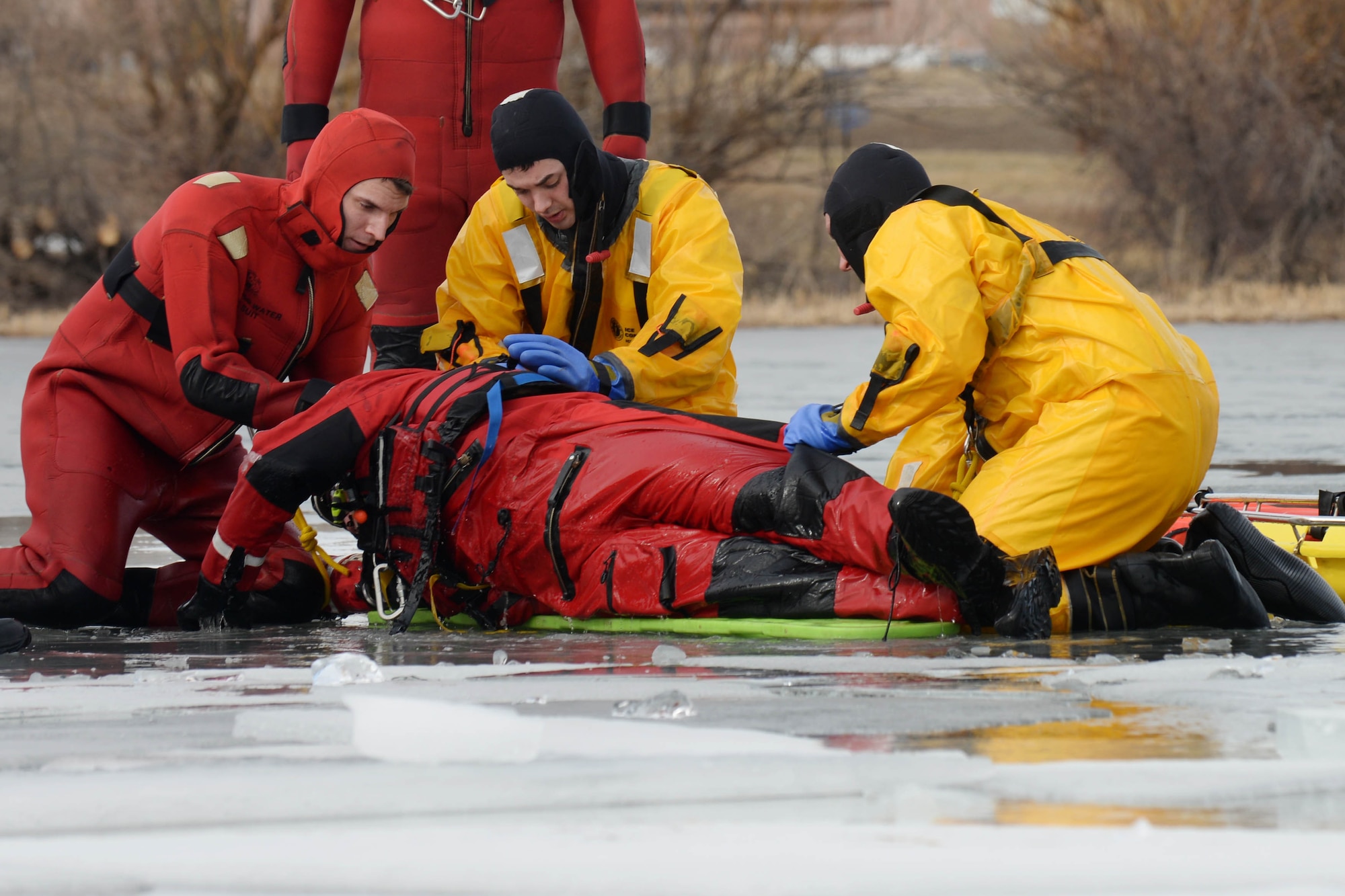 Airmen from the 28th Civil Engineer Squadron Fire Department roll over a simulated victim during ice rescue training at Ellsworth Air Force Base, S.D., Feb. 17, 2016. Obtaining the skills and knowledge to save a life makes ice rescue training a valuable tool. (U.S. Air Force photo by Senior Airman Rebecca Imwalle/Released)