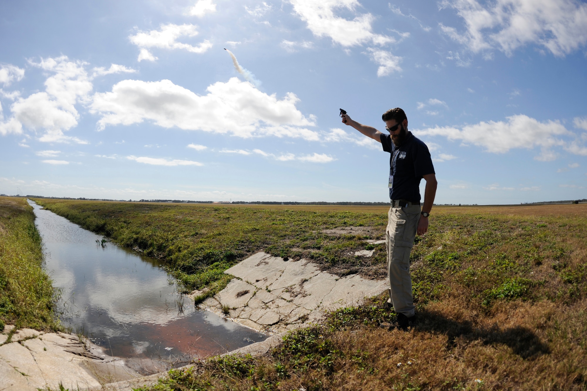 Kory McLellan, a wildlife biologist with the United States Department of Agriculture, uses pyrotechnics to disperse birds away from the airfield, Feb. 16, 2016, at MacDill Air Force Base, Fla. The loud noise of the pyrotechnics provides an effective tool to disperse birds and prevent bird strikes. (U.S. Air Force photo by Airman 1st Class Mariette Adams) 