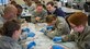 Col. Brian Neese, 628th Medical Operations Squadron commander, (center) talks with Dr. Joseph Sakran, Medical University of South Carolina assistant professor of surgery, about the progress of the medical personnel at Joint Base Charleston – Air Base, S.C., on Feb. 17, 2016. The goal was to improve suturing skills. Suturing is a stitch or series of stitches done to secure the edges of a surgical or traumatic wound. The cooperation between the local civilian medical professionals and JB Charleston’s medical team from the 628th Medical Group is expected to continue. (U.S. Air Force photo/Airman 1st Class Thomas T. Charlton)