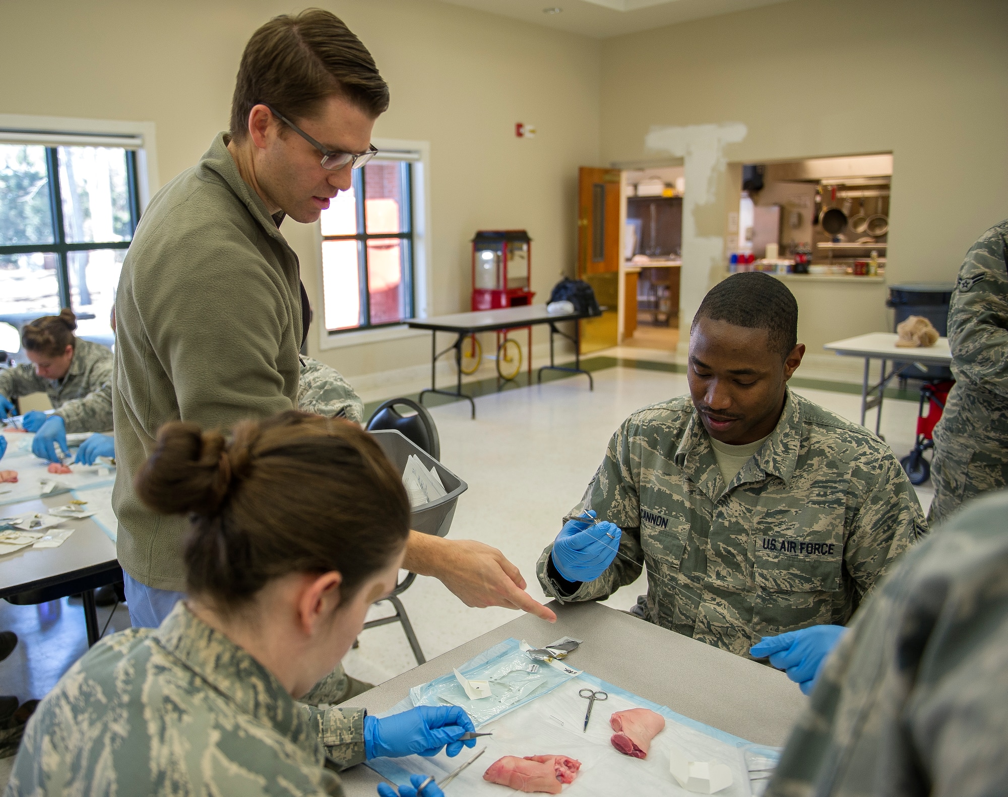 (From left to right) Dr. Brent Jewett, Medical University of South Carolina trauma critical care fellow, explains to Senior Airman Quinton Cannon, 628th Medical Group medical technician, how to properly suture at Joint Base Charleston – Air Base, S.C., on Feb. 17, 2016. Suturing is a stitch or series of stitches done to secure the edges of a surgical or traumatic wound. (U.S. Air Force photo/Airman 1st Class Thomas T. Charlton)