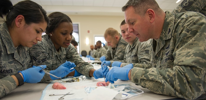 Airman 1st Class Ashley Madry, 628th Medical Group medical technician, helps Col. Robert Lyman, Joint Base Charleston commander, understand and learn how to suture on a pig’s foot on JB Charleston – Air Base, S.C., on Feb. 17, 2016. This training session was the first time that JB Charleston’s medical team interacted and worked with local civilian medical teams to advance their medical skills. (U.S. Air Force photo/Airman 1st Class Thomas T. Charlton)