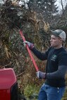 Senior Airman John Seaton, 627th Civil Engineer Squadron structural journeyman, throws plants in the back of a truck after cutting them down off the banks of Morey Pond on Joint Base Lewis-McChord, Wash, Feb. 27, 2016. Removing the overgrown plants will create a better habitat for the fish living in the pond. (U.S. Air Force photo/Senior Airman Divine Cox)
