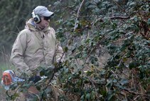 Maj. John Brindle, 627th CES operation flight commander, cuts down some overgrown plants surrounding Morey Pond on Joint Base Lewis-McChord, Wash, Feb. 27, 2016. Morey Pond is located on McChord Field near Holiday Park, allowing JBLM service members and their families the chance to fish on base. (U.S. Air Force photo/Senior Airman Divine Cox)