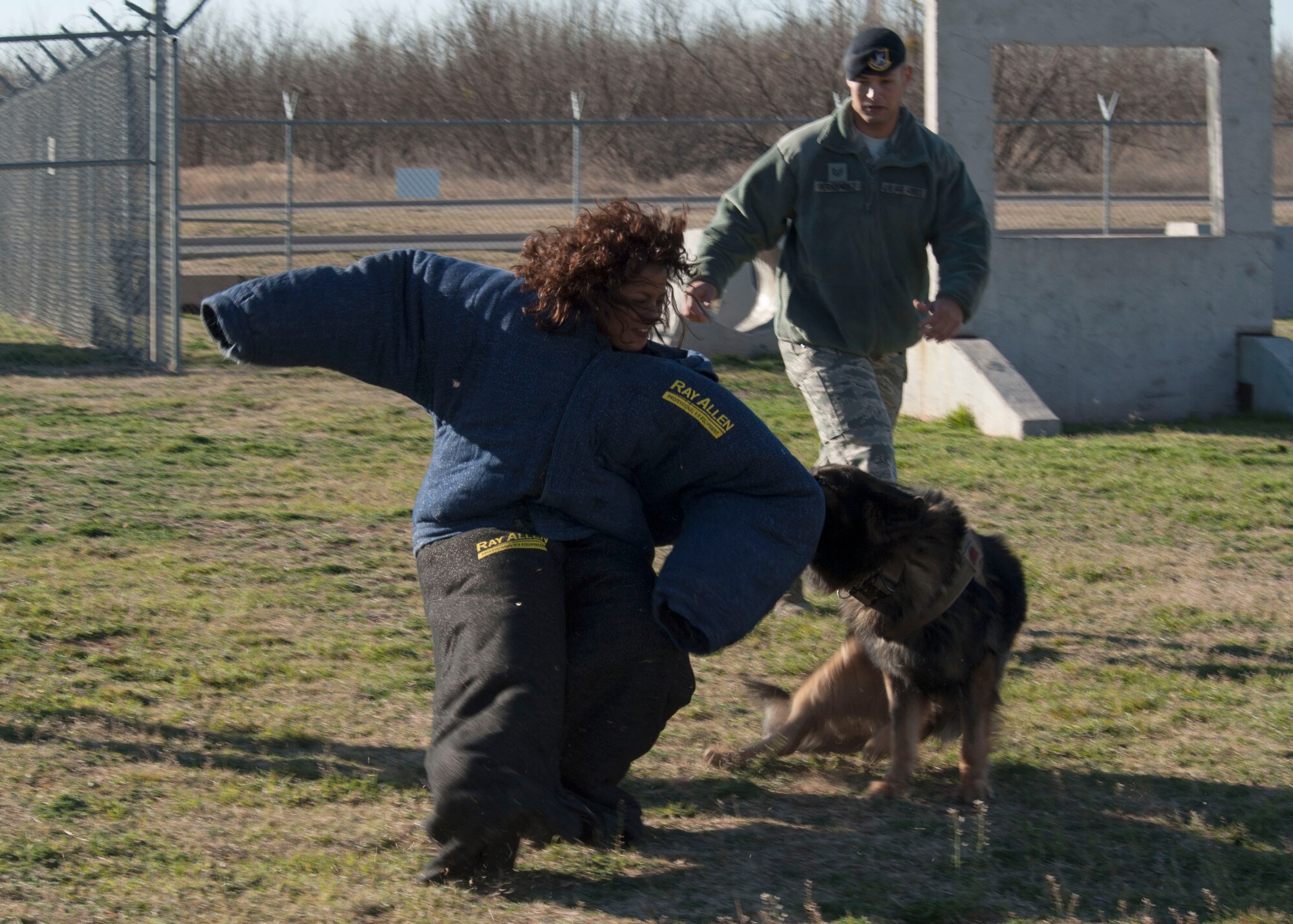 Mrs. Amy Clark, wife of Maj. Gen. Richard M. Clark, and Technical Sgt. Andre Hernandez, 7th Security Forces Squadron K-9 Trainer, preform a military working dog demonstration on Feb. 17, 2016, at Dyess Air Force Base, Texas. Mrs. Clark accompanied her husband to Dyess to visit with Airmen and their families to learn more about how they support the Dyess and Air Force missions. (U.S. Air Force photo by Airman First Class Katherine Miller/Released)
