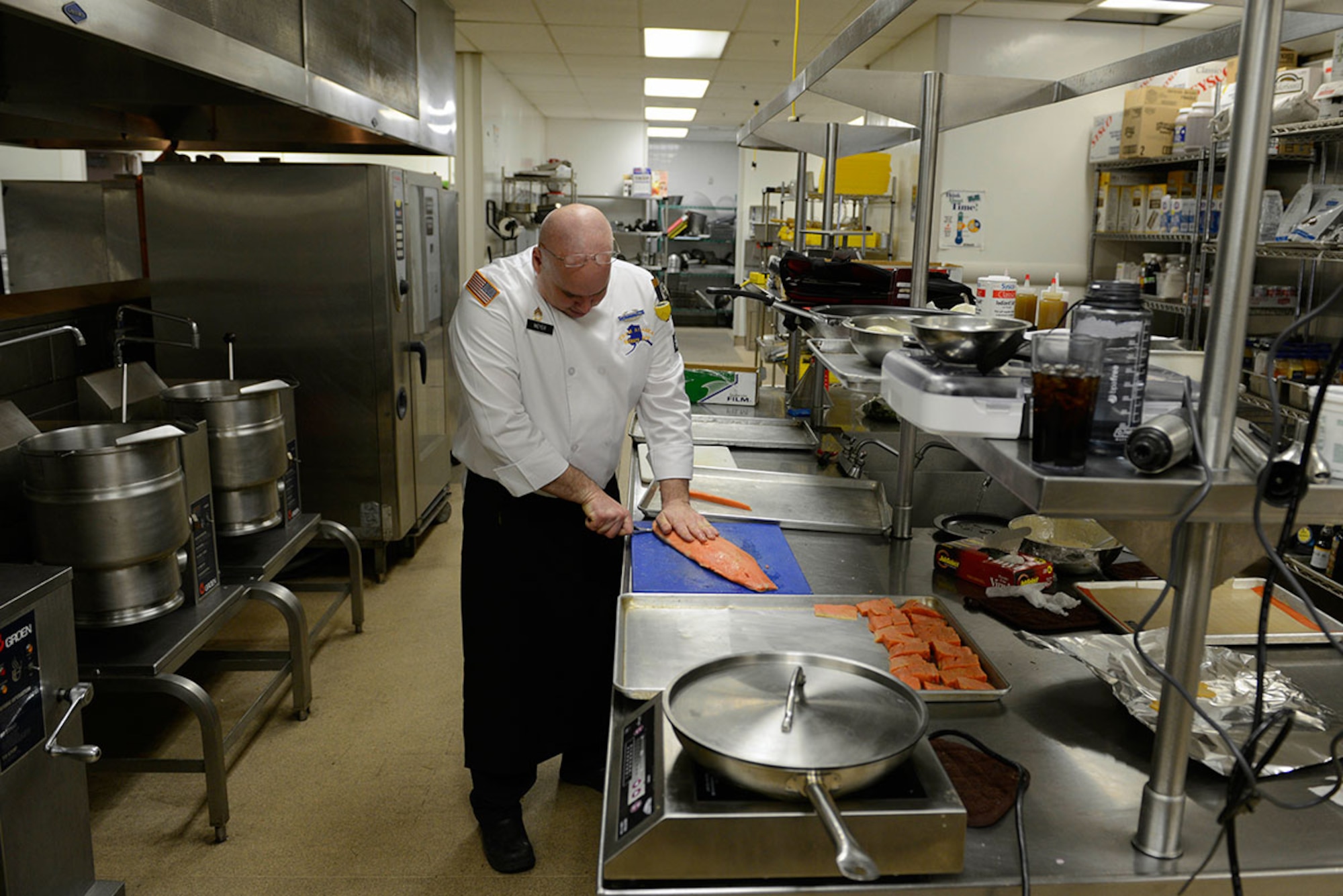 Sgt. 1st Class Ian Meyer, 539th Composite Truck Company, 17th Combat Sustainment Support Battalion, Team Alaska manager, fillets salmon at the Gold Rush Inn Dining Facility at Joint Base Elmendorf-Richardson, Feb. 24, 2016.  The 10-person team of Soldiers and Airmen, served up a three-course meal as part of a training event designed to prepare the team for the 41st Annual Military Culinary Arts Competitive Training Event at Fort Lee, VA., March 5 to 10. (U.S. Air Force photo by Airman Valerie Monroy)