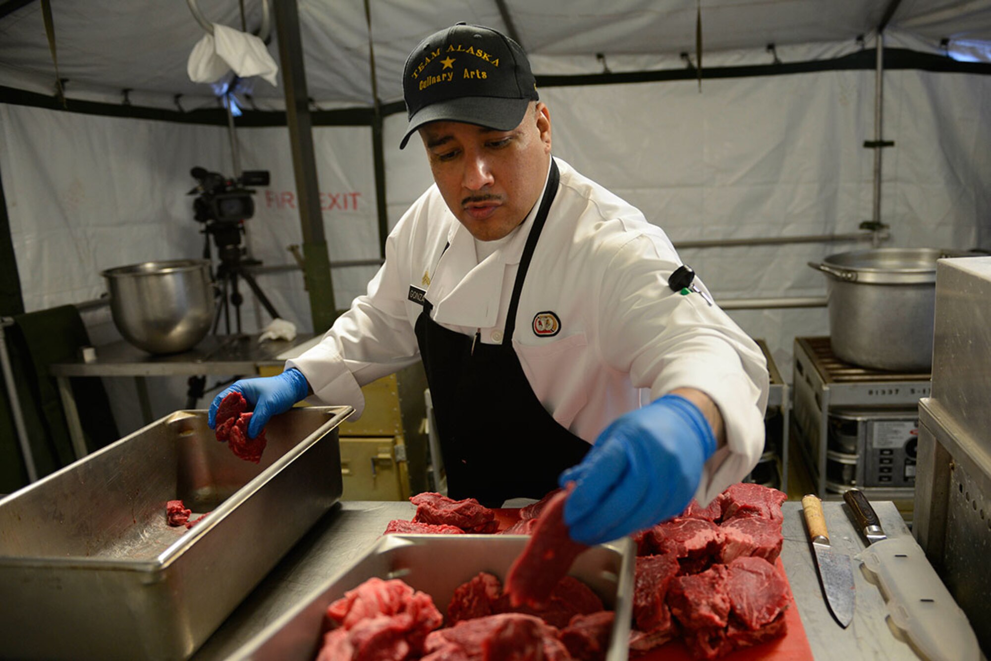 Sgt. Abraham Gonzales, F Company, 725th Brigade Support Battalion, ‘Team Alaska’ co-captain, organizes steaks in a mobile kitchen trailer at Joint Base Elmendorf-Richardson, Feb. 24, 2016.  The 10-person team of Soldiers and Airmen served up a three-course meal as part of a training event designed to prepare the team for the 41st Annual Military Culinary Arts Competitive Training Event at Fort Lee, VA., March 5 to 10. (U.S. Air Force photo by Airman Valerie Monroy)