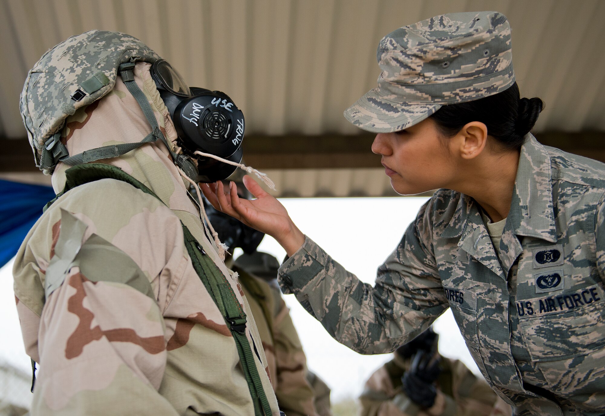 Staff Sgt. Vikki Flores, 96th Civil Engineer Group, ensures an Airman is properly protected during a chemical, biological, radiological, nuclear and explosive training session at Eglin Air Force Base, Fla., Feb. 23.  The course was preparatory training with instructors prior to the live CBRNE exercise.  The Airmen were taught the proper procedures during the training before performing them by themselves during the exercise.  (U.S. Air Force photo/Samuel King Jr.)
