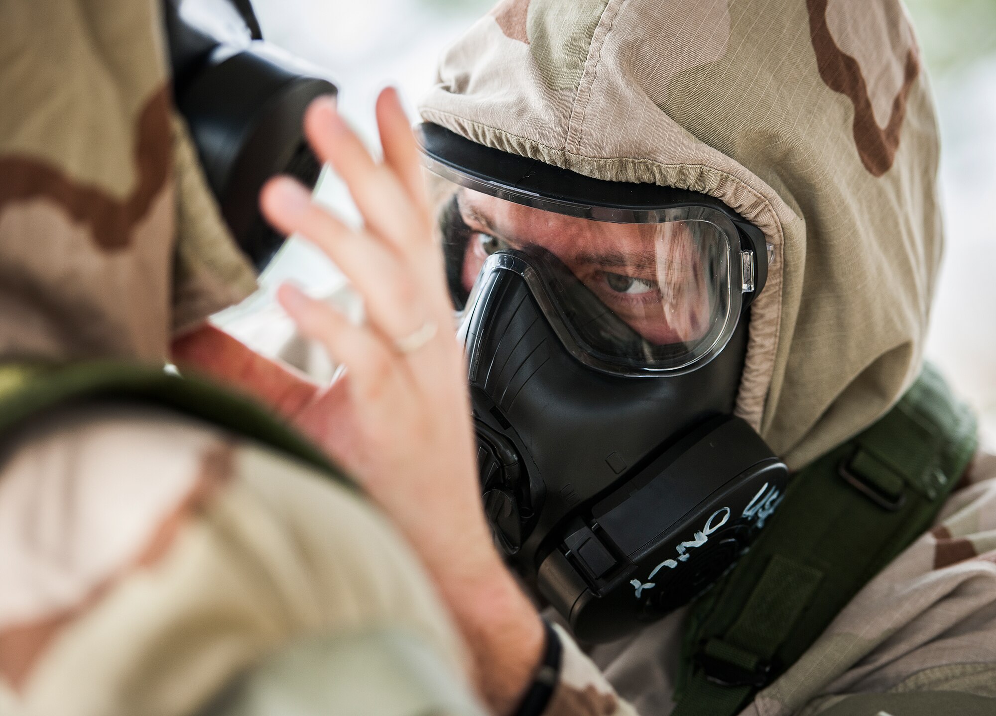 An Airman checks the neck protection of his wingman during a chemical, biological, radiological, nuclear and explosive training session at Eglin Air Force Base, Fla., Feb. 23.  The course was preparatory training with instructors prior to the live CBRNE exercise.  The Airmen were taught the proper procedures during the training before performing them by themselves during the exercise.  (U.S. Air Force photo/Samuel King Jr.)