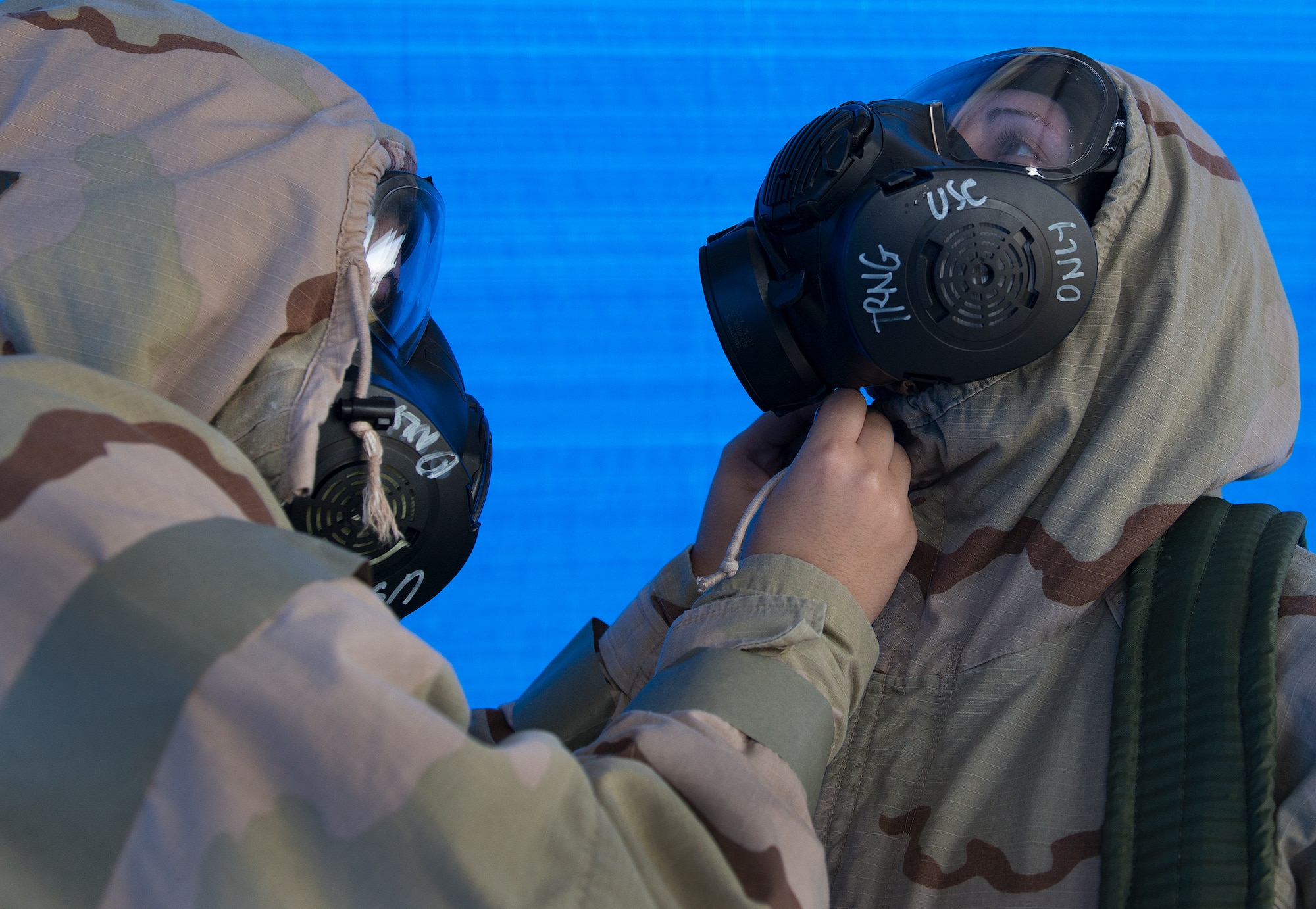 An Airman helps his wingman secure his protection gear during a chemical, biological, radiological, nuclear and explosive exercise at Eglin Air Force Base, Fla., Feb. 23.  The exercise evaluated the Airmen’s ability to meet wartime and contingency taskings of employing and sustaining the force and the ability to survive and operate.  (U.S. Air Force photo/Samuel King Jr.)