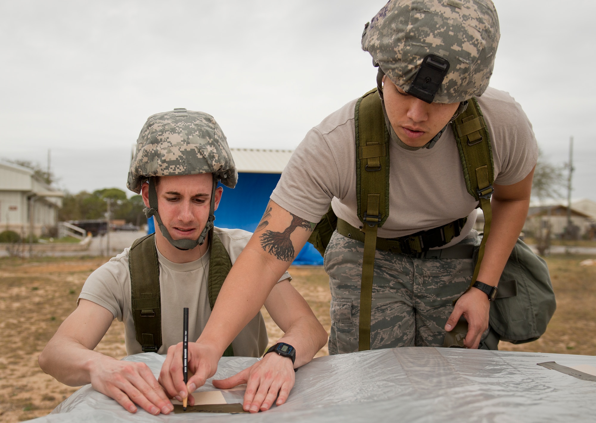Airmen work together to mark the M8 contamination paper tape during a chemical, biological, radiological, nuclear and explosive exercise at Eglin Air Force Base, Fla., Feb. 23.  The exercise evaluated the Airmen’s ability to meet wartime and contingency taskings of employing and sustaining the force and the ability to survive and operate.  (U.S. Air Force photo/Samuel King Jr.)