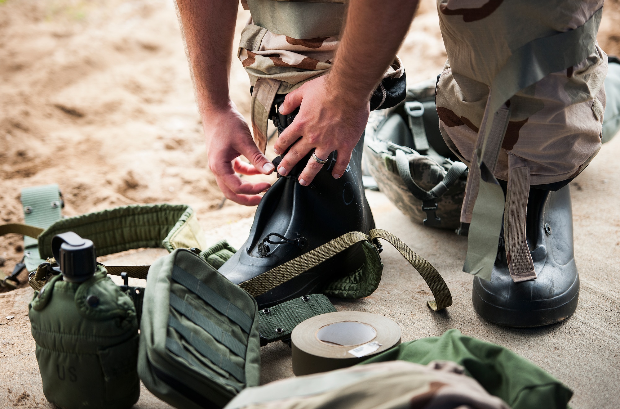 An Airman dons his protective gear during a chemical, biological, radiological, nuclear and explosive exercise at Eglin Air Force Base, Fla., Feb. 23.  The exercise evaluated the Airmen’s ability to meet wartime and contingency taskings of employing and sustaining the force and the ability to survive and operate.  (U.S. Air Force photo/Samuel King Jr.)