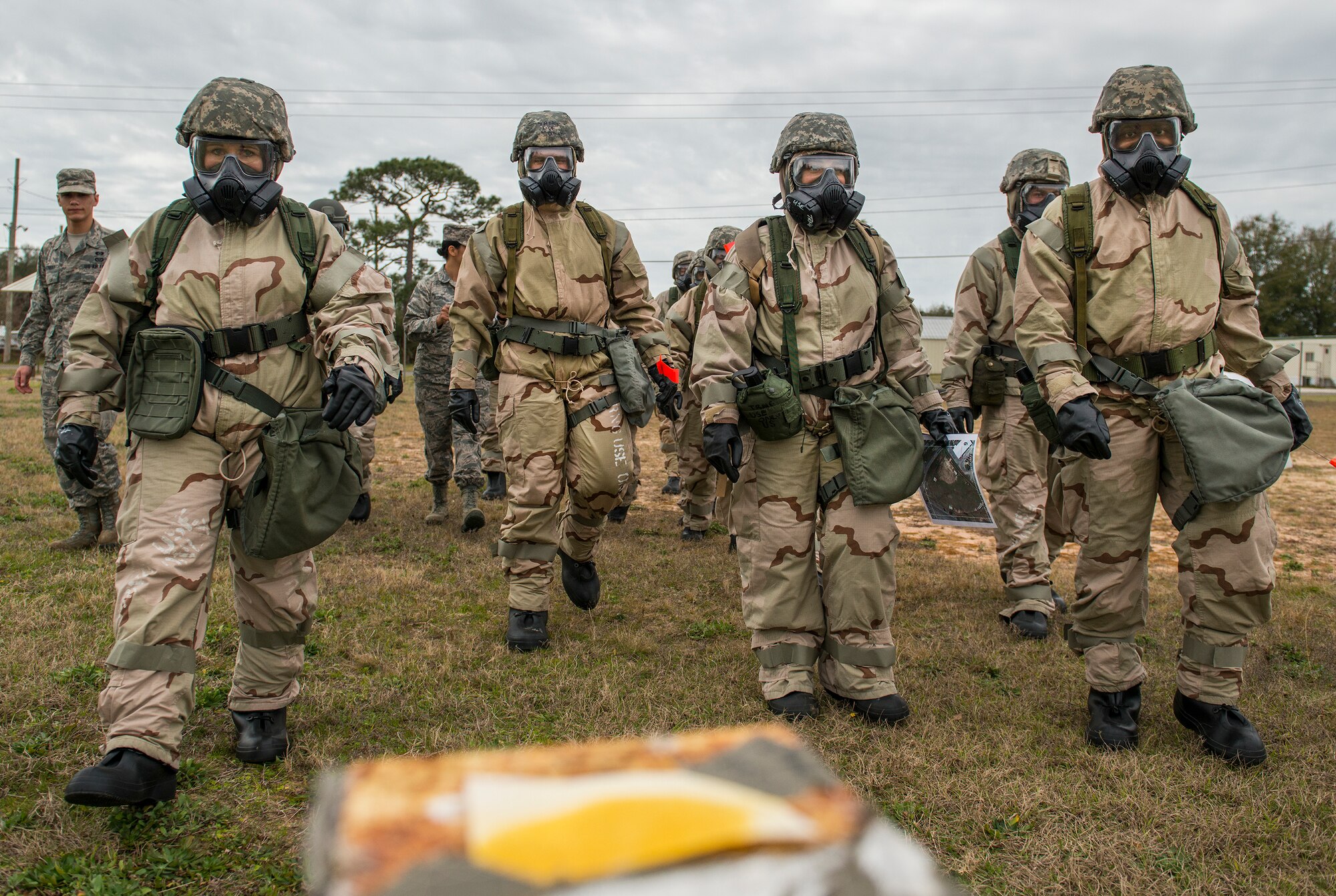 A team of Airmen approach a contaminated piece of M8 paper during a chemical, biological, radiological, nuclear and explosive training session at Eglin Air Force Base, Fla., Feb. 23.  The course was preparatory training with instructors prior to the live CBRNE exercise.  The Airmen were taught the proper procedures during the training before performing them by themselves during the exercise.  (U.S. Air Force photo/Samuel King Jr.)