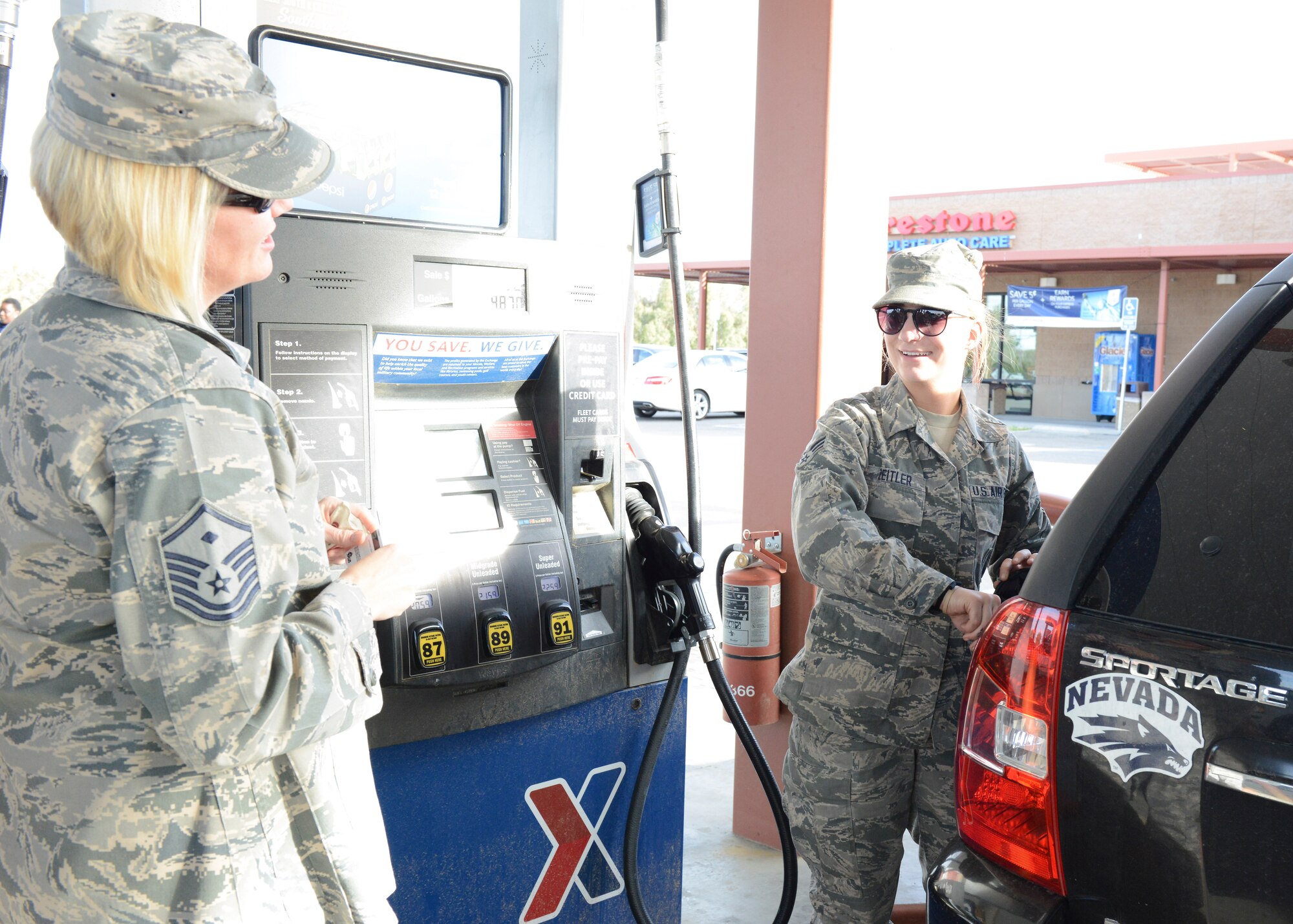 Master Sgt. Laura Magas (left), 412th Operations Group, surprises Senior Airman Kelli Zeitler, 412th Aircraft Maintenance Squadron, as she gets ready to pump gas at the Edwards Express gas station Feb. 26. The Edwards First Sergeants Council bought a tank of gas for about 20 Airmen E-5 and below along with spouses married to junior Airmen. The event was titled, Random Acts of Kindness. (U.S. Air Force photo by Kenji Thuloweit)