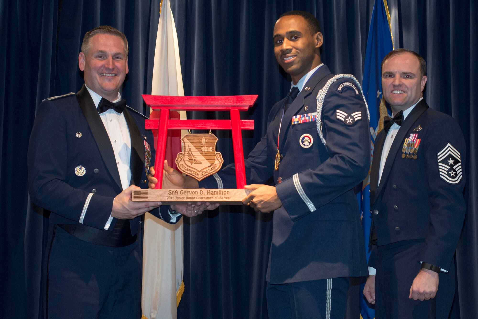 Senior Airman Gervon Hamilton, 374th Medical Support Squadron, receives the 2015 Junior Honor Guardsman of the Year Award at Yokota Air Base, Japan, Feb. 19, 2016. (U.S. Air Force photo by Senior Airman David Danford/Released)		