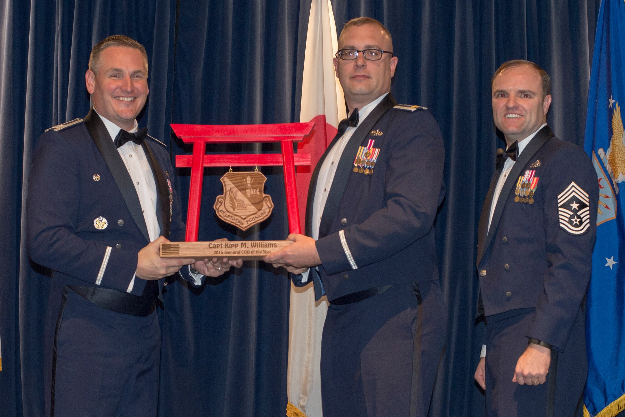 In place of Capt. Kipp M. William, 374th Maintenance Group, Maj. Brian Waller, receives the 2015 Samurai CGO of the Year Award at Yokota Air Base, Japan, Feb. 19, 2016. (U.S. Air Force photo by Senior Airman David Danford/Released)	