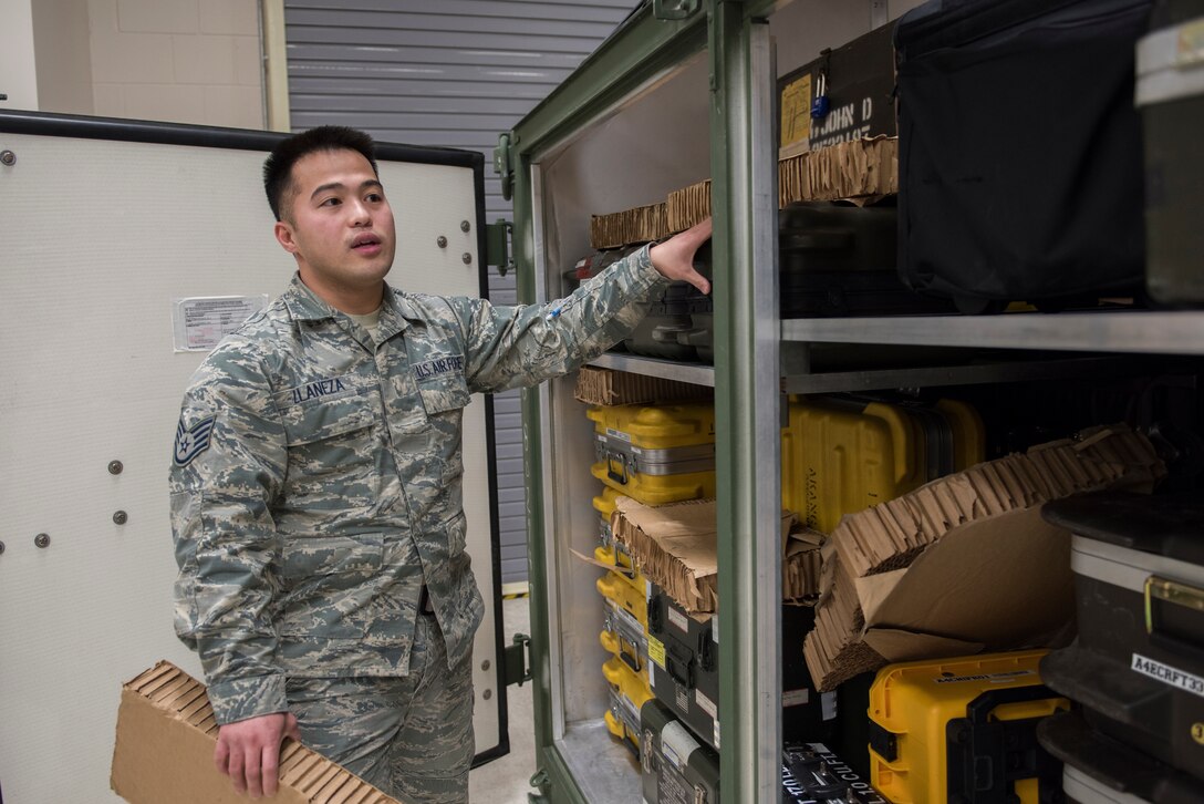 Staff Sgt. Mark Llaneza, an aviaonics technician with the 176th Maintenance Squadron, explains the importance of a shipping container housing the tools required to maintain the 176th Wing’s C-130 Hercules aircraft here Feb. 5, 2016. The container will be packed to go with deployers down range in an upcoming mission. (U.S. Air National Guard photo by Tech. Sgt. N. Alicia Halla/Released)