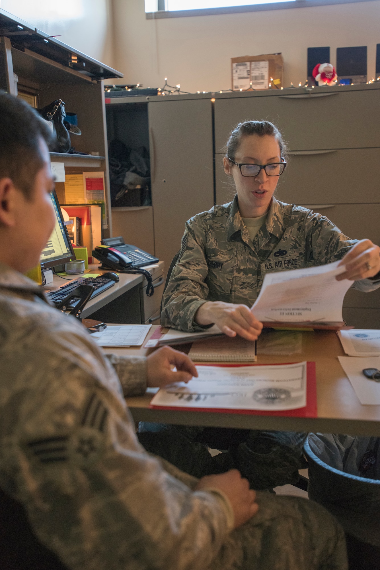 Tech. Sgt. Allison Cherry, the 176th Maintenance Group deployment manager, goes through 176th MXS-member Senior Airman Saechal’s paperwork here Feb. 5, 2016, as he prepares to deploy. (U.S. Air National Guard photo by Tech. Sgt. N. Alicia Halla/Released)