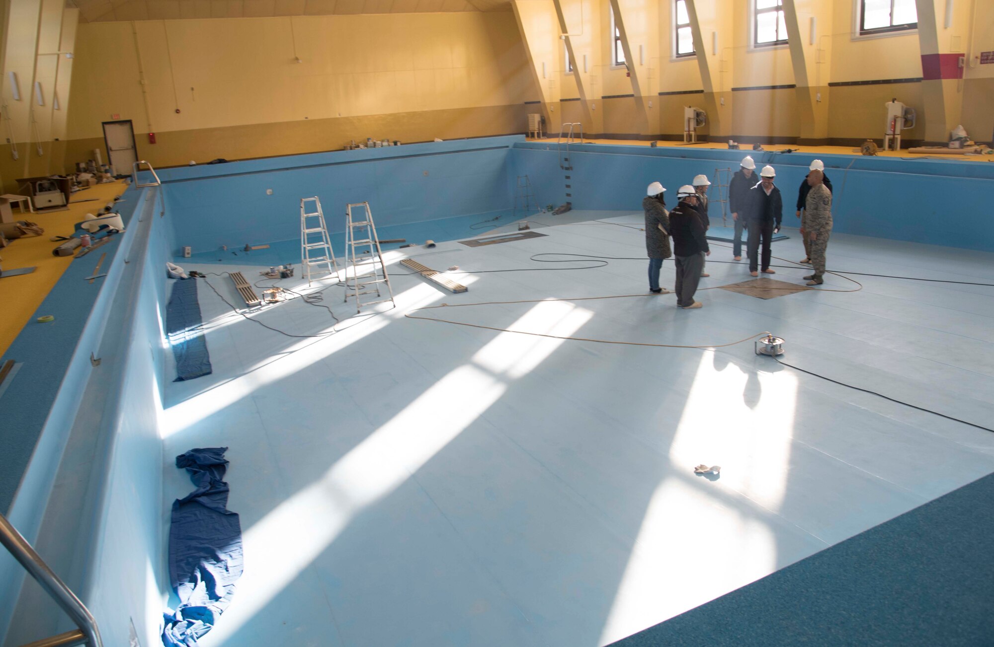 A group of 35th Contracting Squadron members and local contractors discuss the Himberg Pool construction at Misawa Air Base, Japan, Feb. 3, 2016. The project took place due to the materialization of scratches and bubbles of the pool’s vinyl liner which was last worked on more than 10 years ago. The condition prompted the replacement of the liner and base plate, taking approximately seven months to complete. (U.S. Air Force photo by Airman 1st Class Jordyn Fetter) 