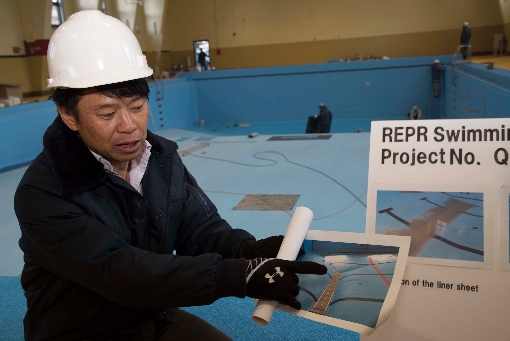 Satoshi Nogawa, chief of construction flight with the 35th Contracting Squadron, discusses the previous condition of the Himberg Pool at Misawa Air Base, Japan, Feb. 3, 2016. After the 35th Civil Engineer Squadron and an outside contracting company surveyed the state of the pool in September 2014, the vinyl liner and base plate were determined to need replacing. (U.S. Air Force photo by Airman 1st Class Jordyn Fetter)