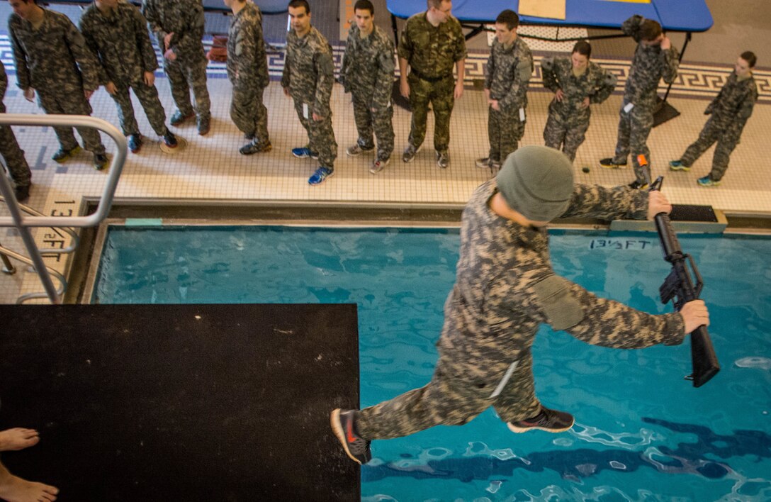 A Clemson University Reserve Officers Training Corps cadet steps off a five-meter diving board - blindfolded - during the Combat Water Survival Test in the Fike Recreation Center Jan. 29, 2015. Cadets had to maintain control of their weapon after hitting the water and return to the side of the pool with it to pass the event. The CWST evaluates each cadet’s stamina in water and their ability to complete three stations while wearing a uniform. Passing the events helps ensure they have the fundamental water survival skills necessary to lead soldiers in a hostile environment where there’s water. (Photo by Ken Scar)